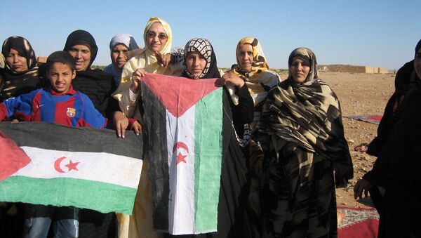 Saharawis holding up flags of the Saharawi Arab Democratic Republic in Western Sahara, 2006 - Sputnik International