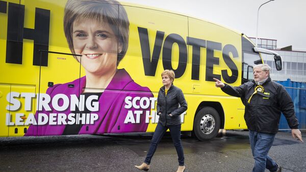 Scotland's First Minister and leader of the Scottish National Party (SNP), Nicola Sturgeon (R) walks past the campaign battle bus with SNP candidate Angus Robertson during a campaign visit to LOVE Gorgie Farm in Edinburgh, Scotland on May 4, 2021, ahead of the upcoming Scottish Parliament election which is to be held on May 6, 2021. - Sputnik International