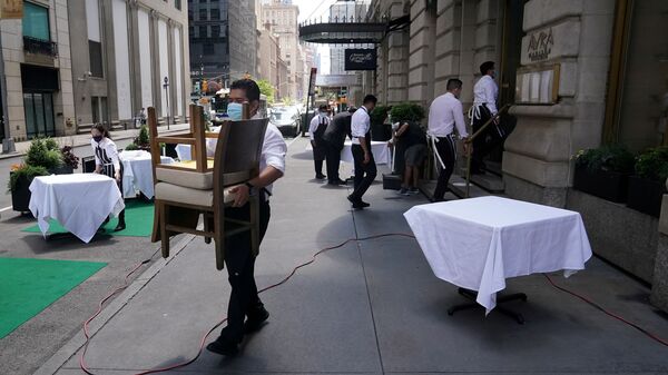 FILE PHOTO: A waiter sets up tables in front of a restaurant on a street on the first day of the phase two re-opening of businesses following the outbreak of the coronavirus disease (COVID-19), in the Manhattan borough of New York City, New York, U.S., June 22, 2020.  - Sputnik International