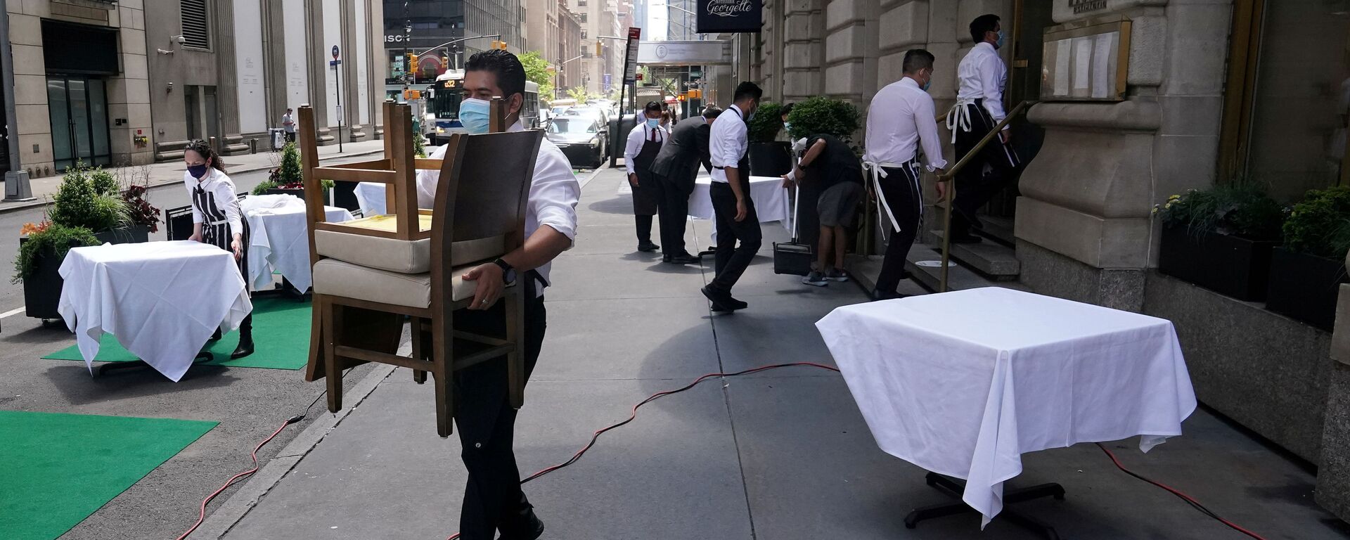FILE PHOTO: A waiter sets up tables in front of a restaurant on a street on the first day of the phase two re-opening of businesses following the outbreak of the coronavirus disease (COVID-19), in the Manhattan borough of New York City, New York, U.S., June 22, 2020.  - Sputnik International, 1920, 06.12.2021