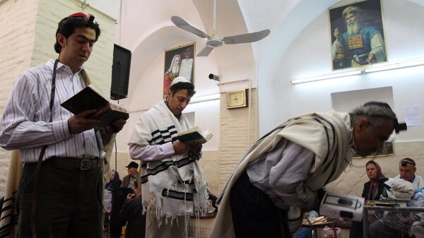 Standing under pictures of the Jewish Prophet Moses, Iranian Jewish men pray in a synagogue as they attend  a ceremony to commemorate Rabbi Harav Orsharga, a descendent of King David who died two centuries ago, in Yazd (670kms, 410 miles) south of Tehran, Iran, on Thursday, Nov. 8, 2007. - Sputnik International
