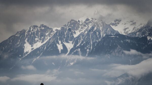 A man is seen in silhouette in a bad weather with snowy Alps mountains in the background on February 2, 2021 in Lausanne. - Sputnik International