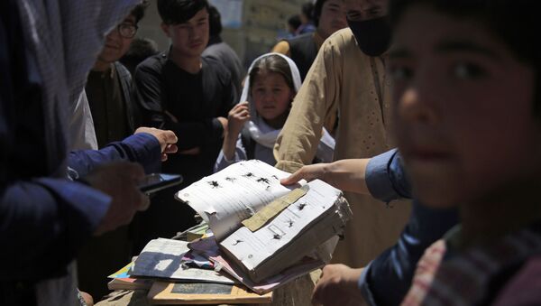 Afghans go through belongings left behind after deadly bombings on Saturday near a school in Kabul, Afghanistan, 9 May 2021.  - Sputnik International