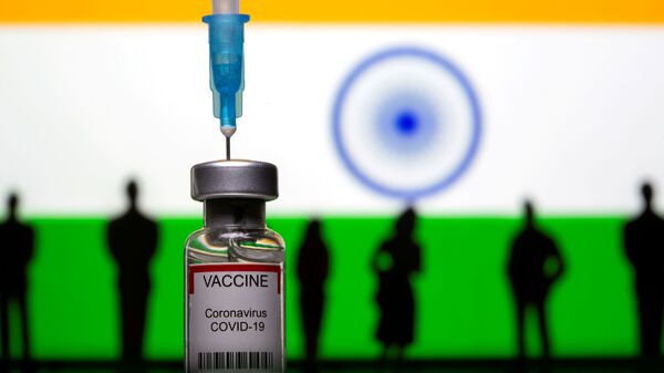 3D-printed small toy figurines, a syringe and vial labelled coronavirus disease (COVID-19) vaccine are seen in front of India flag - Sputnik International