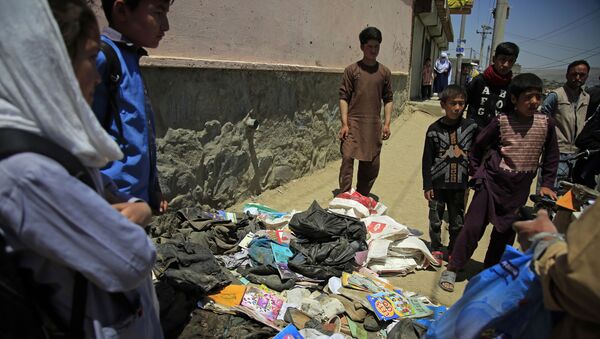 Afghans go through belongings left behind after deadly bombings on Saturday near a school in Kabul, Afghanistan, Sunday, May 9, 2021.  - Sputnik International