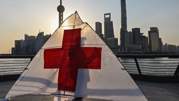 This picture taken on March 23, 2020 shows Gu, 80, wearing a facemask as a preventive measure against the spread of the COVID-19 novel coronavirus, as he prepares to fly his kite in the early morning on the promenade of the Bund along Huangpu River in Shanghai. - Sputnik International