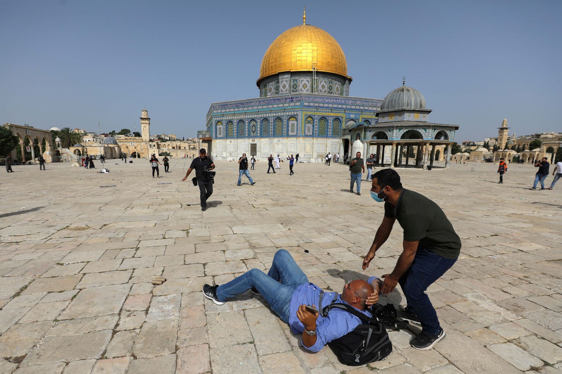 A cameraman is helped by a Palestinian after falling on the ground during clashes with Israeli police at the compound that houses Al-Aqsa Mosque, known to Muslims as Noble Sanctuary and to Jews as Temple Mount, in Jerusalem's Old City, May 10, 2021.  - Sputnik International, 1920, 07.09.2021