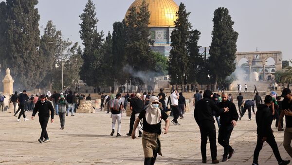 Palestinians run for cover from tear gas fired by Israeli security forces at Jerusalem's Al-Aqsa mosque compound on May 10, 2021, ahead of a planned march to commemorate Israel's takeover of Jerusalem in the 1967 Six-Day War.  - Sputnik International