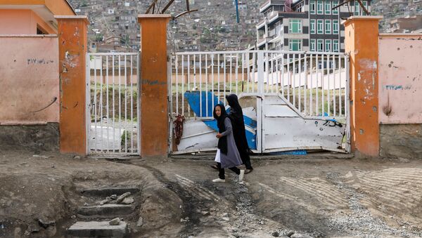 A woman with a girl walks past the site of a car bomb blast that targeted schoolgirls in Kabul, Afghanistan May 10, 2021.  - Sputnik International