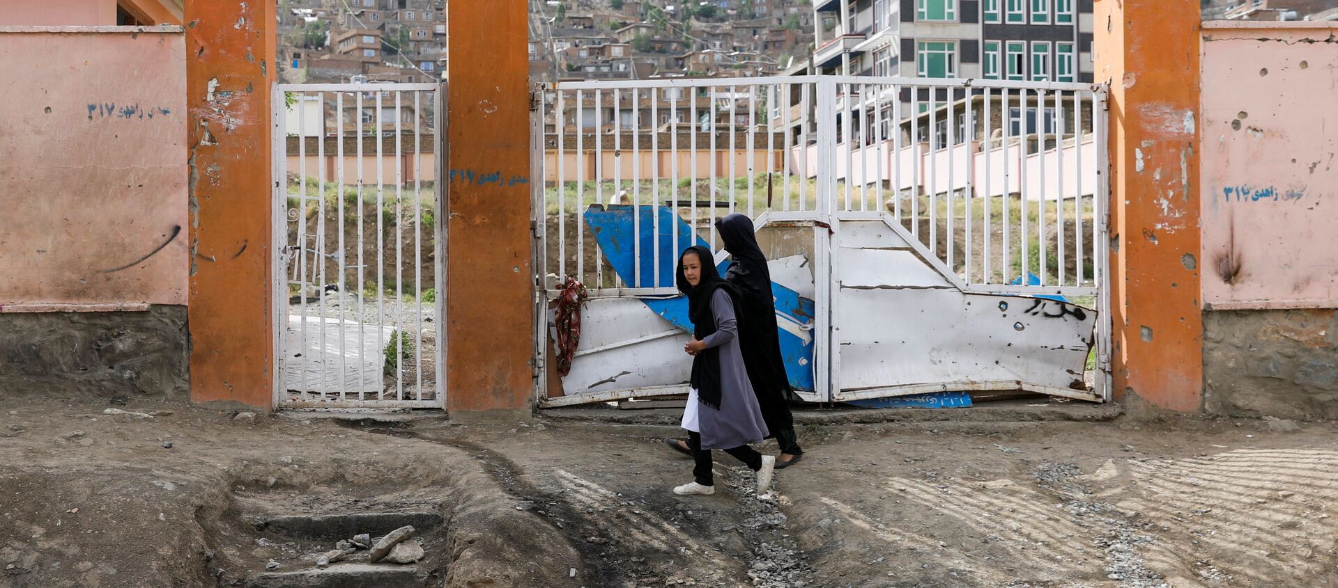 A woman with a girl walks past the site of a car bomb blast that targeted schoolgirls in Kabul, Afghanistan May 10, 2021.  - Sputnik International, 1920, 19.05.2021