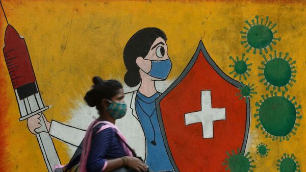 A woman walks past a graffiti on a street, amidst the spread of the coronavirus disease (COVID-19) in Mumbai, India, May 10, 2021 - Sputnik International