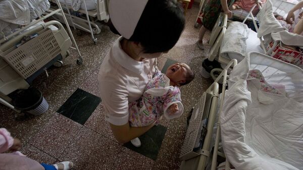 In this photo taken Thursday, July 25, 2013, a nurse holds Baby Liang in a hospital where she was born in Beijing - Sputnik International