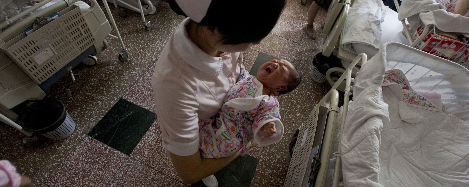 In this photo taken Thursday, July 25, 2013, a nurse holds Baby Liang in a hospital where she was born in Beijing - Sputnik International, 1920, 17.10.2022