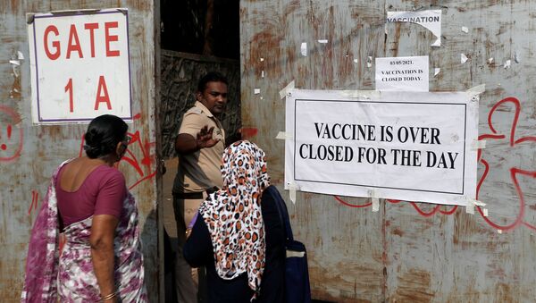 A policeman asks people who came to receive a dose of a coronavirus disease (COVID-19) vaccine to leave as they stand outside the gate of a vaccination centre which was closed due to unavailability of the supply of COVID-19 vaccine, in Mumbai, India, 3 May 2021.  - Sputnik International
