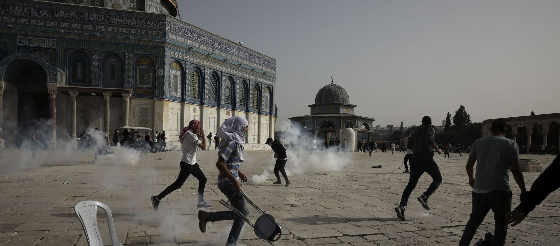 Palestinians run away from tear gas during clashes with Israeli security forces at the Al Aqsa Mosque compound in Jerusalem's Old City Monday, May 10, 2021 - Sputnik International, 1920