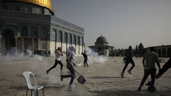 Palestinians run away from tear gas during clashes with Israeli security forces at the Al Aqsa Mosque compound in Jerusalem's Old City Monday, May 10, 2021 - Sputnik International