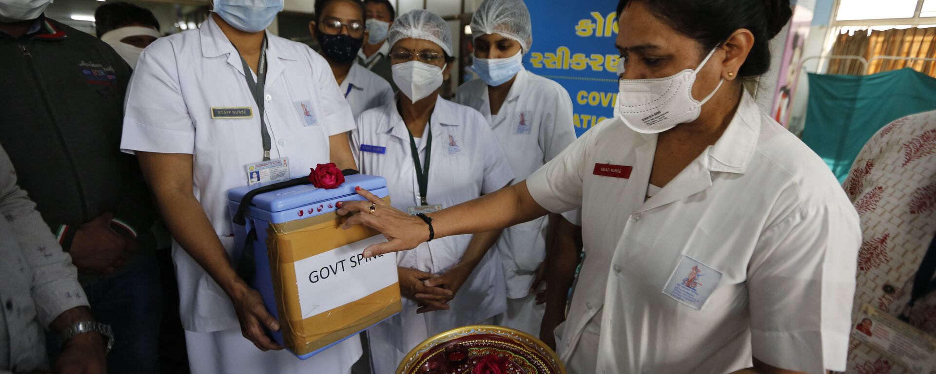 A nurse, right, takes delivery of a box containing COVID-19 vaccines as it arrives at a government hospital in Ahmedabad, Gujarat state, India on Saturday, 16 January 2021. - Sputnik International, 1920, 12.05.2021