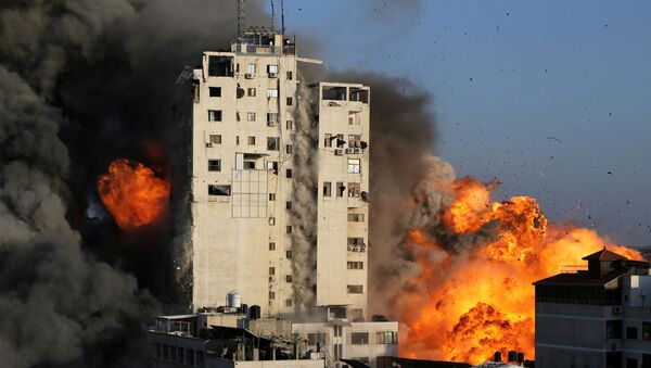 Smoke and flames rise from a tower building as it is destroyed by Israeli air strikes amid a flare-up of Israeli-Palestinian violence, in Gaza City May 12, 2021. - Sputnik International
