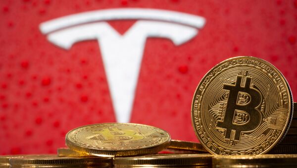 Representations of virtual currency Bitcoin are seen in front of Tesla logo in this illustration taken, February 9, 2021.  - Sputnik International