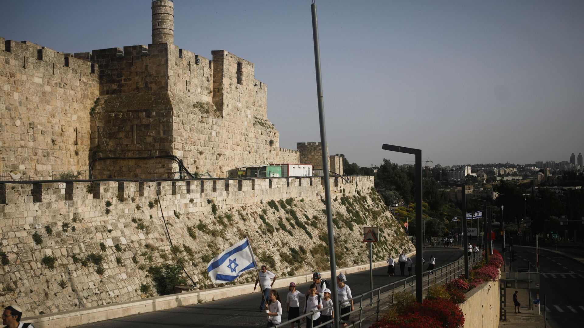 Youths wave an Israeli flag during a parade marking Jerusalem Day, amid Israeli-Palestinian tension, as they walk near the wall surrounding Jerusalem's Old City May 10, 2021. May 10, 2021. - Sputnik International, 1920, 21.10.2021