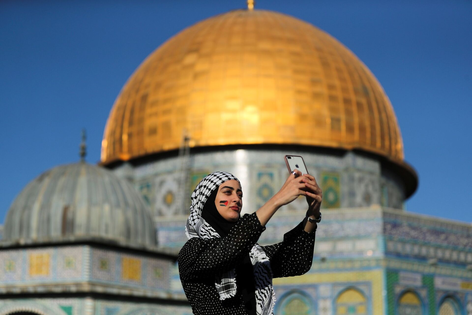 Палестинка снимает селфи на фоне Купола Скалы во время молитвы Ид-аль-Фитр, в Старом городе Иерусалима - Sputnik International, 1920, 28.09.2021