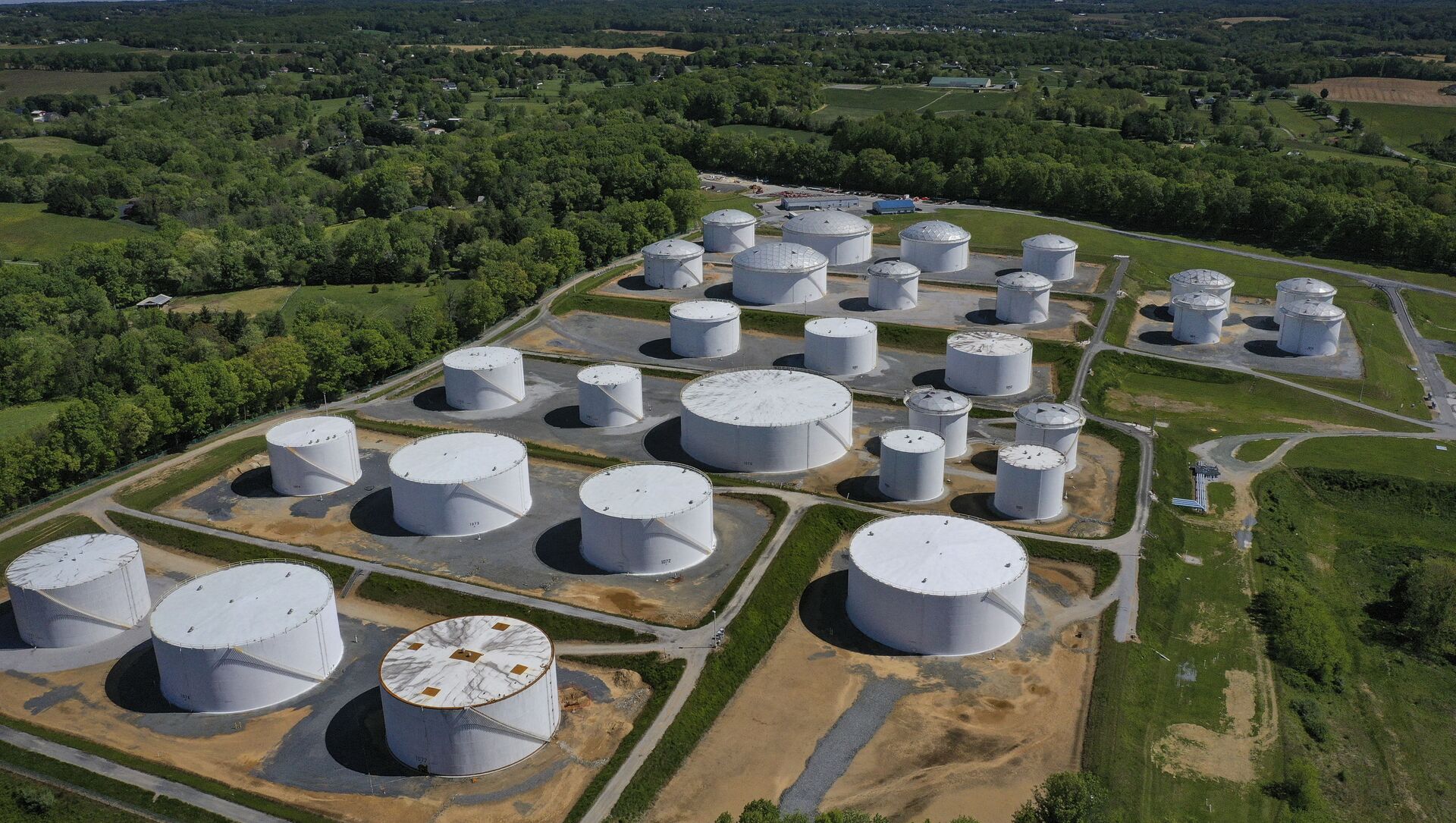 In an aerial view, fuel holding tanks are seen at Colonial Pipeline's Dorsey Junction Station on May 13, 2021 in Washington, DC. The Colonial Pipeline has returned to operations following a cyberattack that disrupted gas supply for the eastern U.S. for days.  - Sputnik International, 1920, 13.05.2021