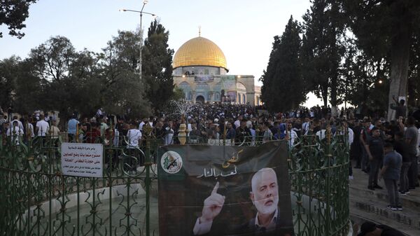A banner depicting Hamas' leader Ismail Haniyeh is on display as Muslims gather for the Eid al-Fitr prayers at the Dome of the Rock Mosque in the Al-Aqsa compound in Jerusalem's Old City on Thursday 13 May 2021. - Sputnik International