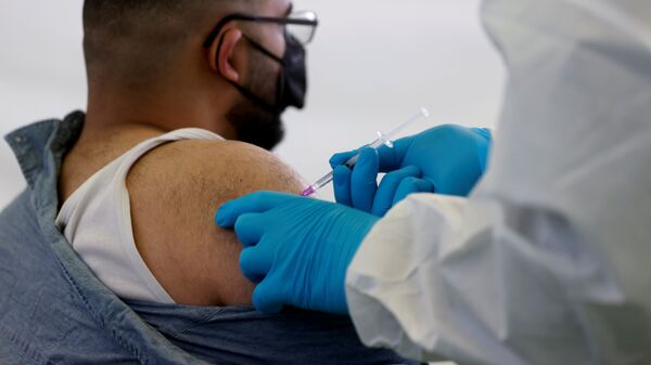 A person receives a vaccine against the coronavirus disease (COVID-19) at a sports hall in Berlin, Germany, May 14, 2021. - Sputnik International