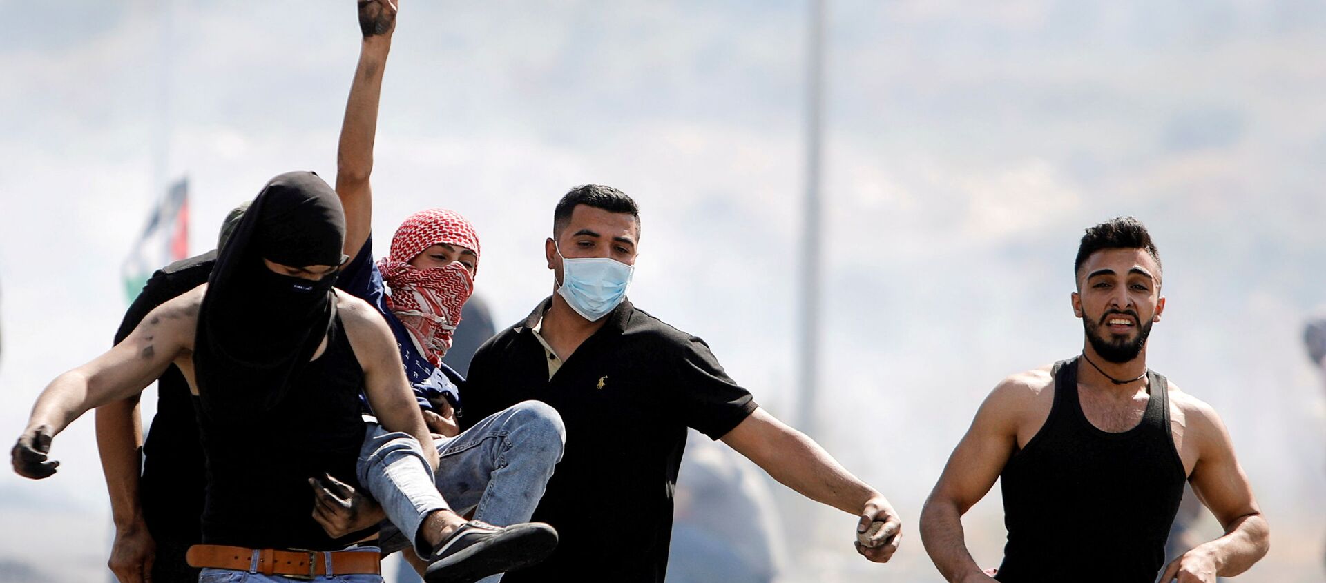 An injured Palestinian demonstrator gestures as he is evacuated during clashes with Israeli forces at a protest over tension in Jerusalem and Israel-Gaza escalation, near Hawara checkpoint near Nablus in the Israeli-occupied West Bank, May 14, 2021. - Sputnik International, 1920