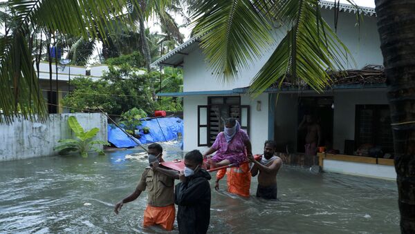 Police and rescue personnel evacuate local residents from a flooded house in a coastal area after heavy rains under the influence of cyclone 'Tauktae' in Kochi on May 14, 2021.  - Sputnik International