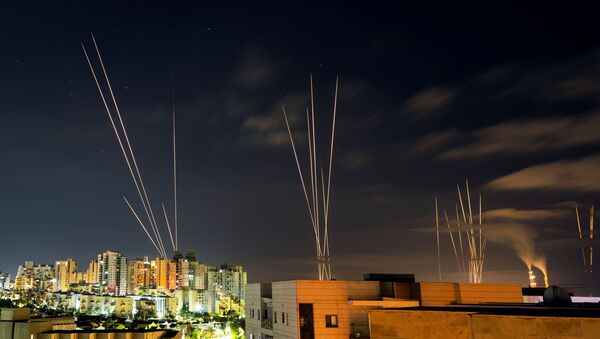Streaks of light are seen as rockets are launched from the Gaza Strip towards central Israel as seen from Ashkelon, Israel May 16, 2021  - Sputnik International