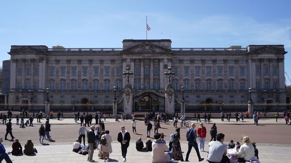 People sit outside Buckingham Palace in central London on April 17, 2021, ahead of the funeral for Britain's Prince Philip, Duke of Edinburgh. - Sputnik International