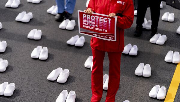 Nurses stand surrounded by white pairs of shoes to represent the 402 nurses who died because of covid-19, near the White House in Washington, Wednesday, May 12, 2021 - Sputnik International