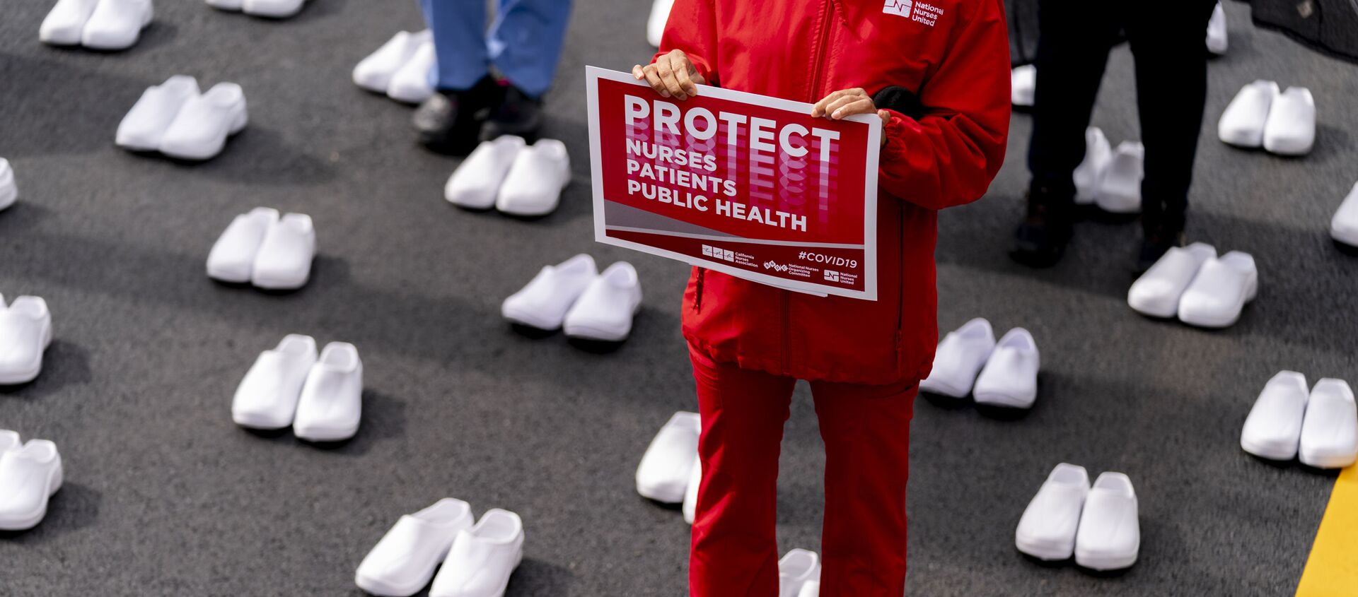Nurses stand surrounded by white pairs of shoes to represent the 402 nurses who died because of covid-19, near the White House in Washington, Wednesday, May 12, 2021 - Sputnik International, 1920, 16.06.2021