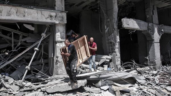 Palestinian men remove salvageable items from the bombarded Al-Jawhara Tower in Gaza City on May 17, 2021, five days after it was targeted by Israeli airstrikes. - Sputnik International