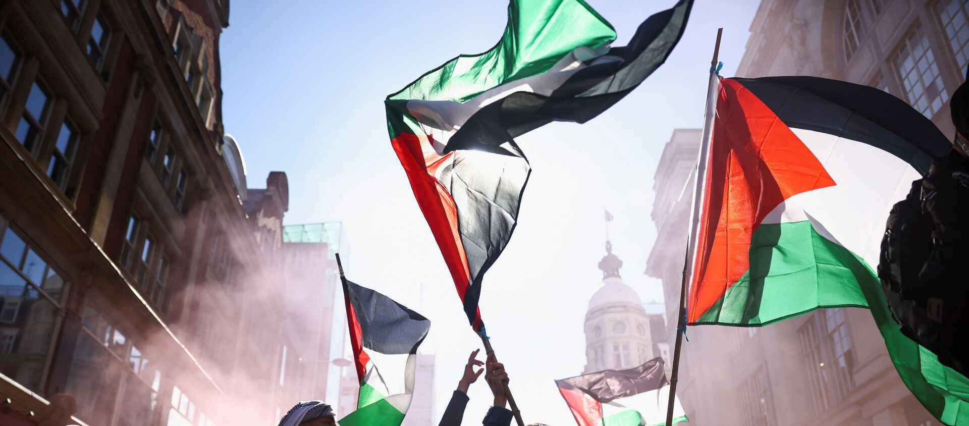 Pro-Palestinian demonstrators hold Palestinian flags, as they attend a protest following a flare-up of Israeli-Palestinian violence, in London, Britain, May 15, 2021. - Sputnik International, 1920, 17.05.2021