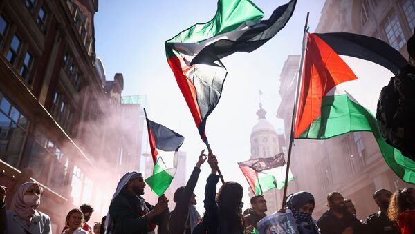 Pro-Palestinian demonstrators hold Palestinian flags, as they attend a protest following a flare-up of Israeli-Palestinian violence, in London, Britain, May 15, 2021. - Sputnik International