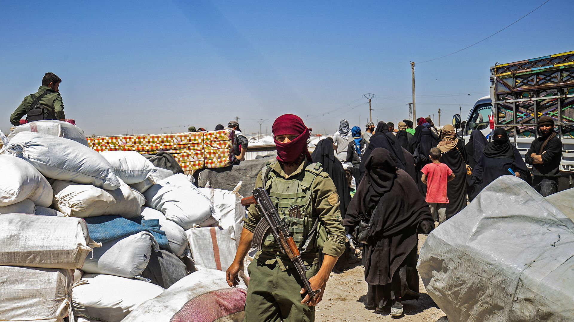 A member of Kurdish security watches preparations as another group of Syrian families is released from the Kurdish-run Al-Hol camp, which holds relatives of suspected Islamic State (IS) group fighters, in the northeastern Syrian Hasakeh governorate, on May 11, 2021 - Sputnik International, 1920, 17.05.2021