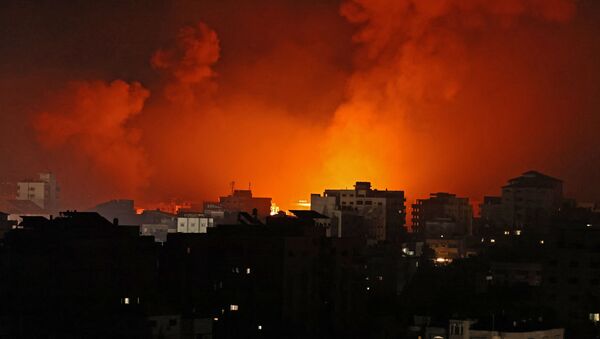 Smoke billows from a fire following Israeli airstrikes on multiple targets in Gaza City, controlled by the Palestinian Hamas movement, early on May 16, 2021.  - Sputnik International