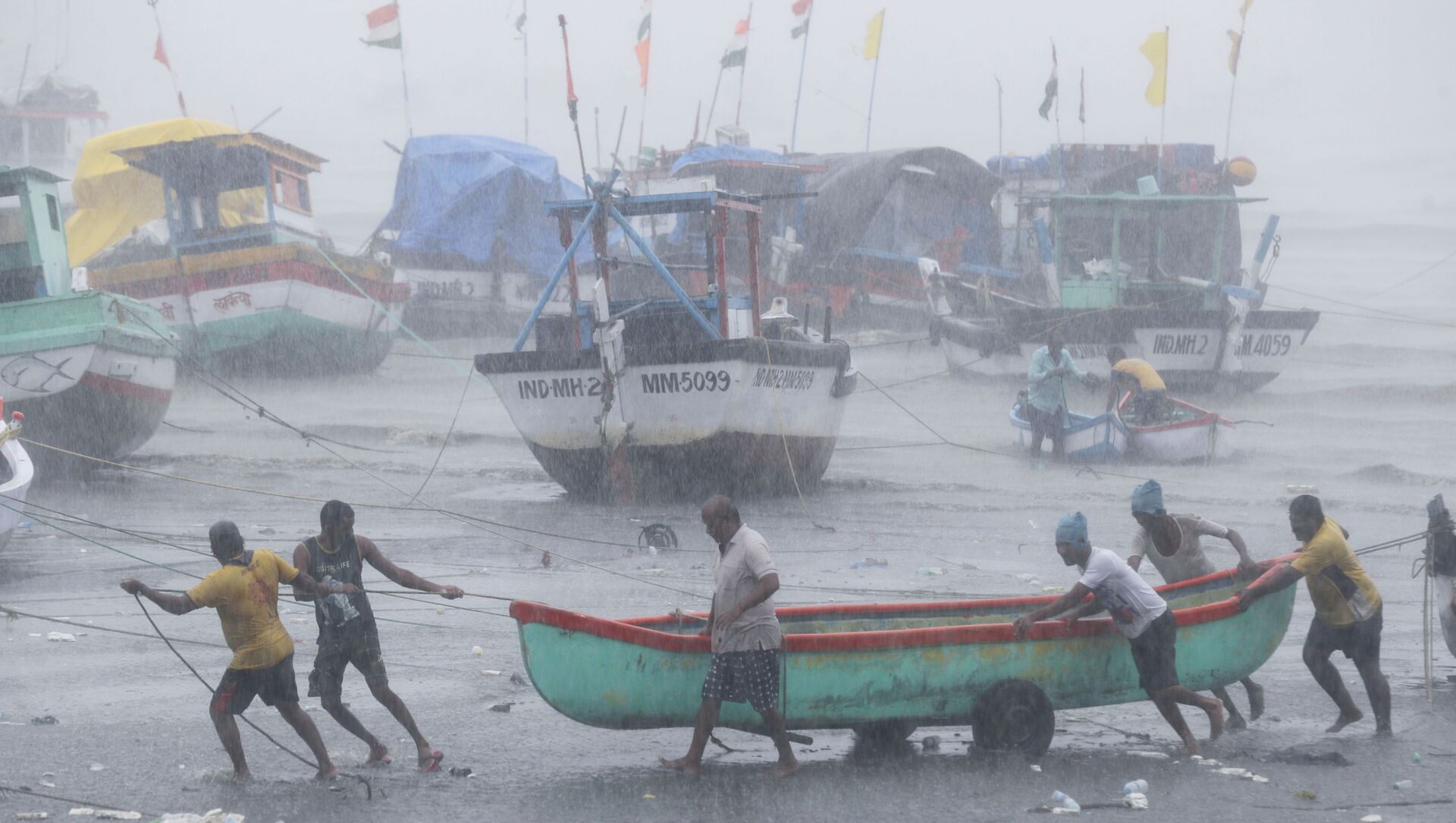 Fishermen try to move a fishing boat to a safer ground on the Arabian Sea coast in Mumbai, India, Monday, May 17, 2021 - Sputnik International, 1920, 18.05.2021