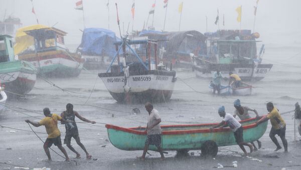 Fishermen try to move a fishing boat to a safer ground on the Arabian Sea coast in Mumbai, India, Monday, May 17, 2021 - Sputnik International
