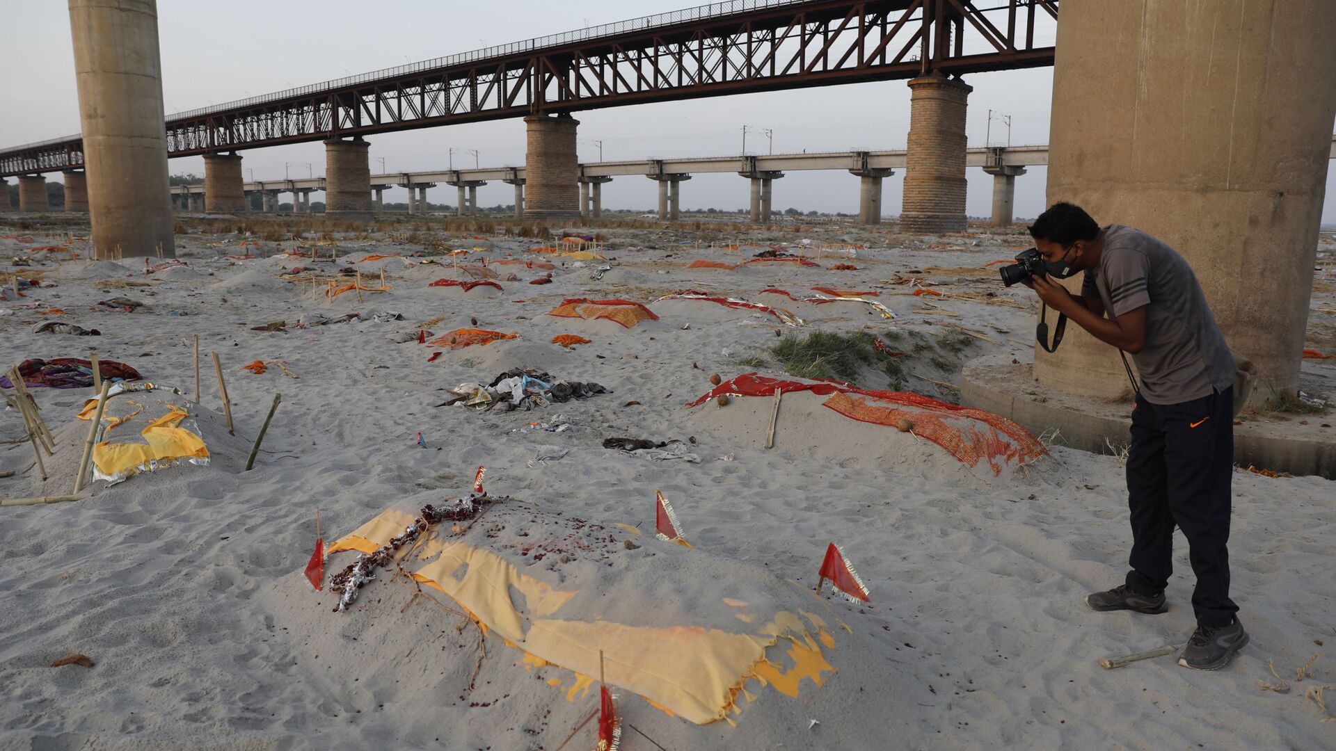 Bodies of suspected Covid-19 victims are seen in shallow graves buried in the sand near a cremation ground on the banks of Ganges River in Prayagraj, India, Saturday, May 15, 2021 - Sputnik International, 1920, 30.04.2022
