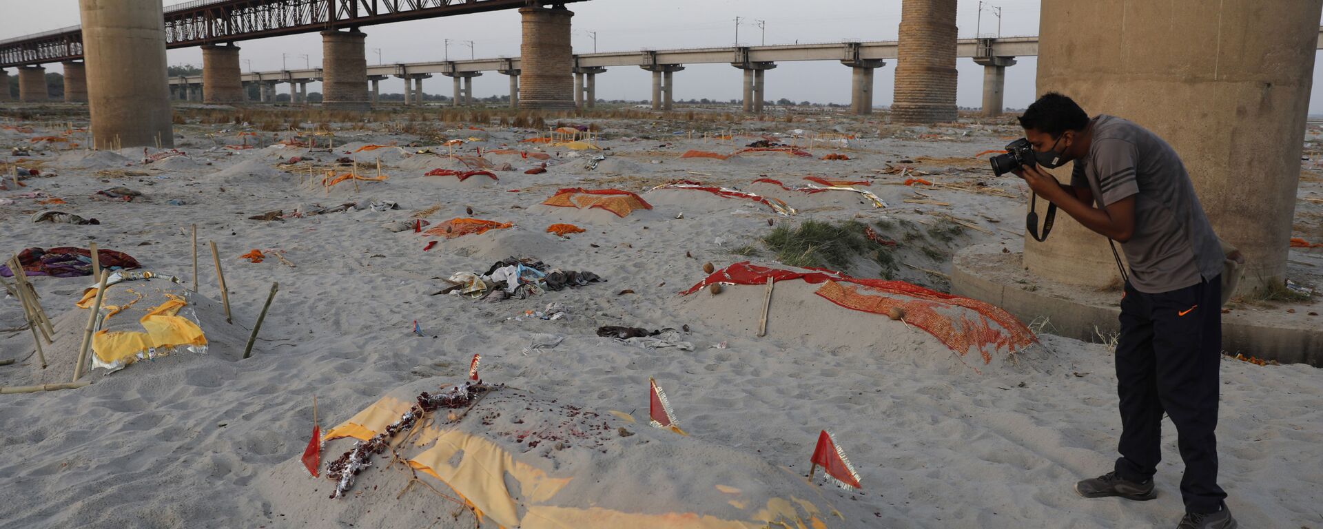 Bodies of suspected Covid-19 victims are seen in shallow graves buried in the sand near a cremation ground on the banks of Ganges River in Prayagraj, India, Saturday, May 15, 2021 - Sputnik International, 1920, 18.05.2021