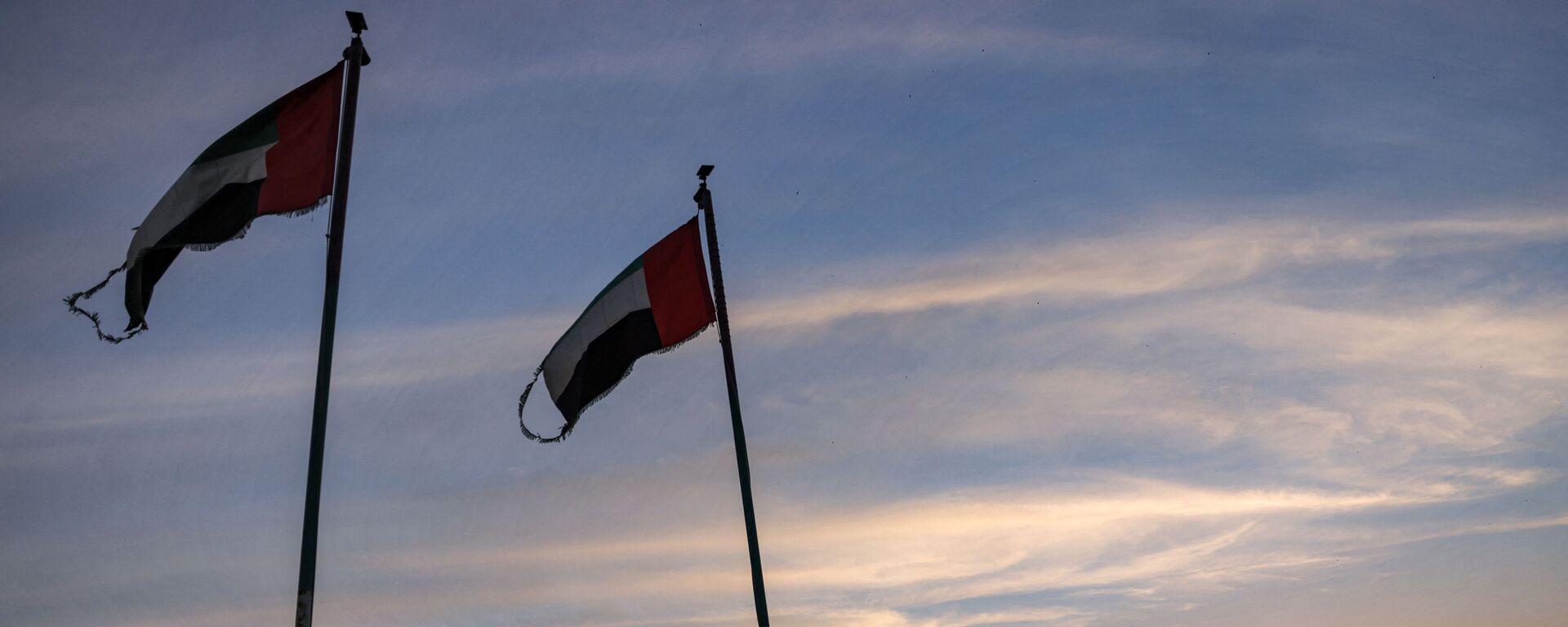 This picture taken on May 2, 2021 shows Emirati flags flying by boats moored along the Dubai creek at sunset. (Photo by GIUSEPPE CACACE / AFP) - Sputnik International, 1920, 18.05.2021