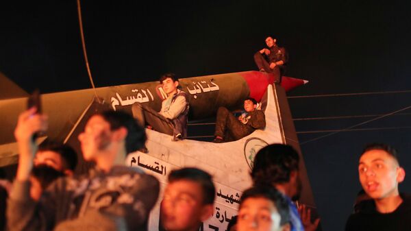 Palestinian demonstrators sit atop a monument of a Hamas rocket during an anti-Israel protest over tension in Jerusalem, in Gaza City April 24, 2021 - Sputnik International
