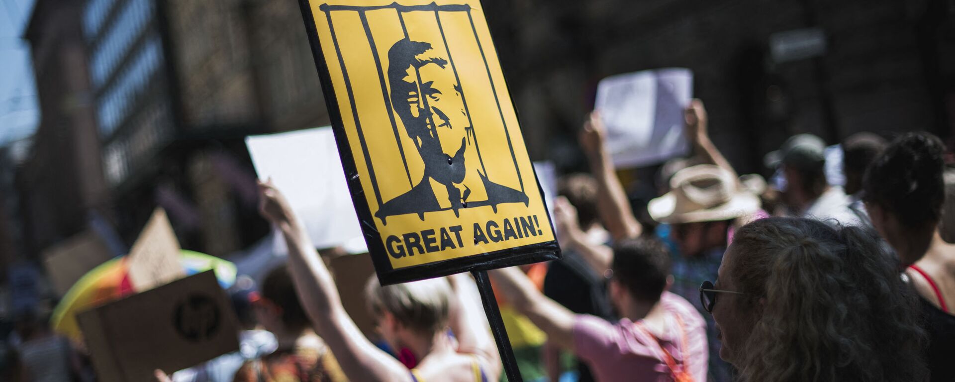 A protester holds a placard featuring US President Donald Trump behinid bars during the so-called Helsinki Calling march towards the Senate Square to defend the human rights, freedom of speech and democracy on July 15, 2018 - Sputnik International, 1920, 21.05.2021