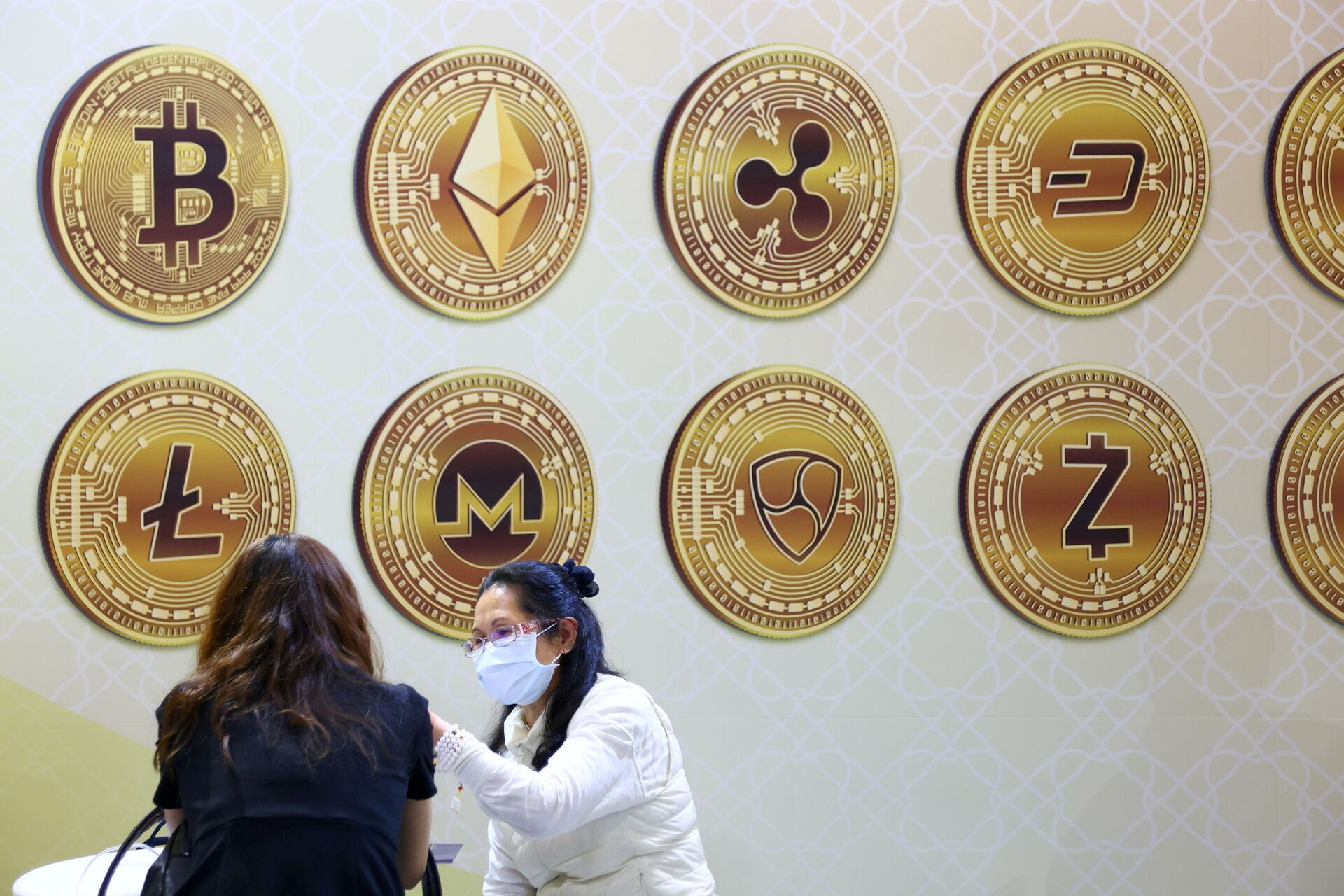 Customers talk against a backboard with signs of cryptocurrency during 2020 Taipei International Finance Expo in Taipei, Taiwan, November 27, 2020. REUTERS/Ann Wang/File Photo - Sputnik International, 1920, 29.01.2022