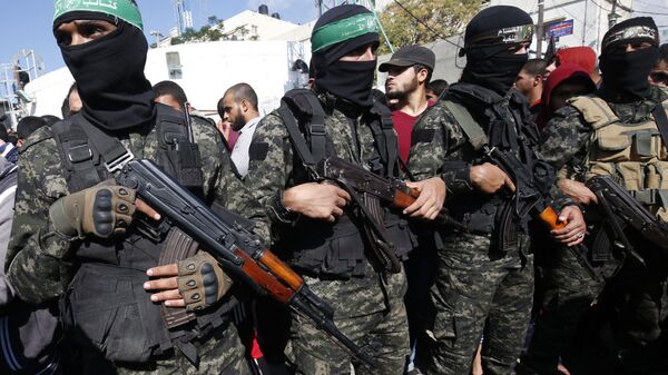 Palestinian militants of the Islamist movement Hamas' military wing Al-Qassam Brigades, attend the funeral of seven Palestinians, killed during an Israeli special forces operation in the Gaza Strip, on November 12, 2018, in Khan Younis - Sputnik International