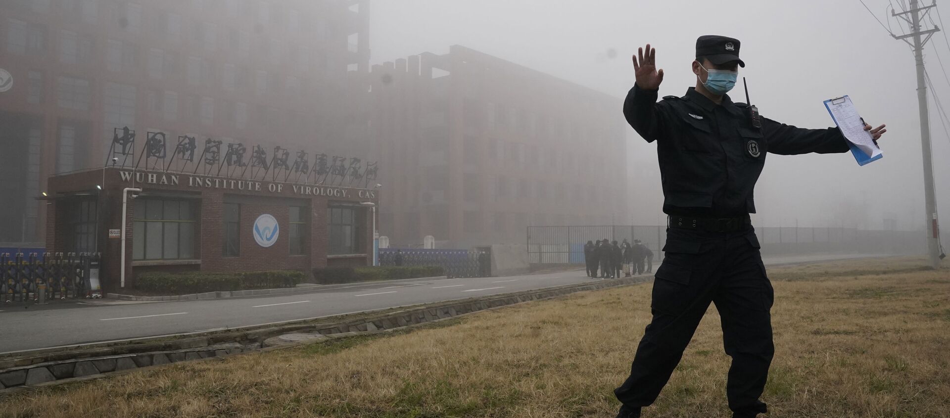 A security official moves journalists away from the Wuhan Institute of Virology after a World Health Organization team arrived for a field visit in Wuhan in China's Hubei province on Wednesday, Feb. 3, 2021 - Sputnik International, 1920