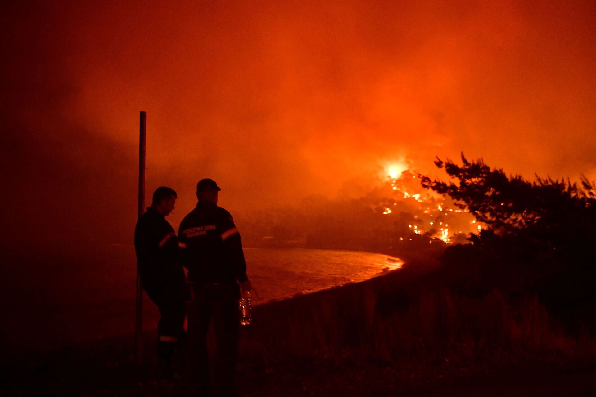 Firefighters look at a wildfire burning next to the beach of the village of Schinos, near Corinth, Greece, May 19, 2021. Picture taken May 19, 2021 - Sputnik International, 1920, 23.12.2021
